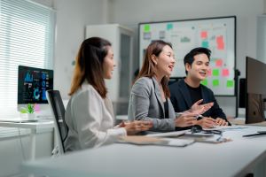 Three professionals discussing data and strategies in an office setting.