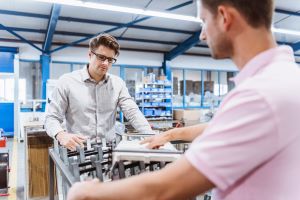 Two engineers discussing a manufacturing process on the production floor.