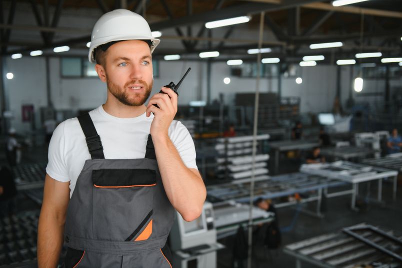 Factory worker using a wireless Andon system for real-time production monitoring.